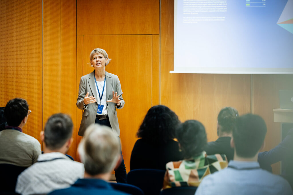 A presentation being given by a businesswoman to a group of participants at a business conference.