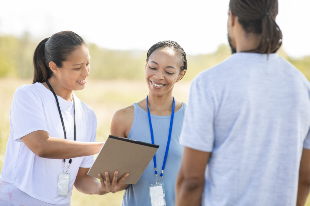 Community health professionals looking at a clipboard in an outdoor setting